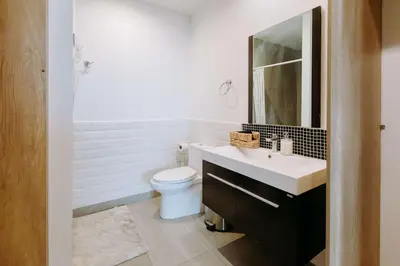 a bathroom with a sink and a toilet and a mirror at Cielo 404 in San Salvador