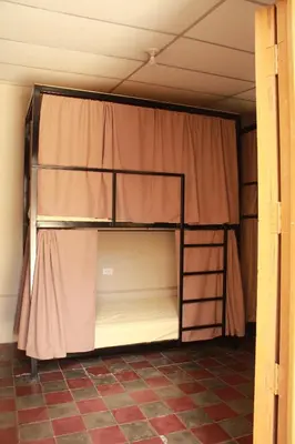 a room with two bunk beds with a curtain at Hostal Casa Nómada in Santa Ana