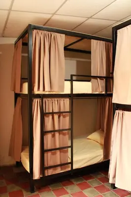 two bunk beds in a room with curtains at Hostal Casa Nómada in Santa Ana
