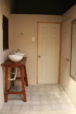 a bathroom with a sink on a table next to a door at Hostal Casa Nómada in Santa Ana