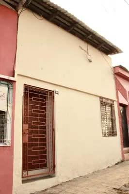 a white building with a brown garage door at Hostal Casa Nómada in Santa Ana