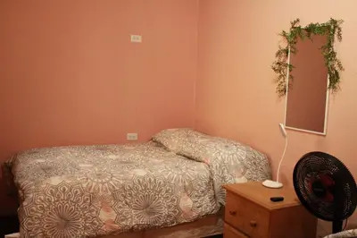 a bedroom with a bed and a mirror and a fan at Hostal Casa Nómada in Santa Ana
