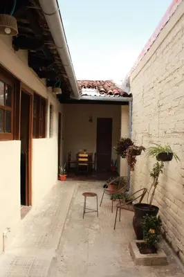 an outdoor patio with chairs and a brick wall at Hostal Casa Nómada in Santa Ana