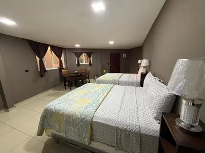 a bedroom with two beds and a dining room at El Mangal 3 B&B in Suchitoto