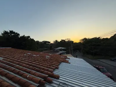 a roof of a building with a sunset in the background at El Mangal 3 B&B in Suchitoto