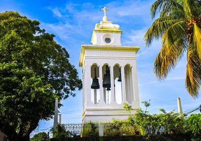 a white clock tower with bells and a cross on it at \u30c4 Izalco Volcano Suites in Izalco