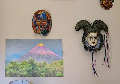 a wall with a painting and a mask on a wall at \u30c4 Izalco Volcano Suites in Izalco