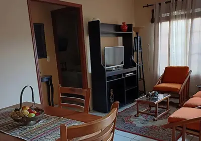 a living room with a table and a television at \u30c4 Izalco Volcano Suites in Izalco