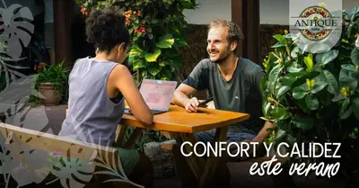 a man sitting at a table next to a woman at Hostal Antique Luna in Santa Ana