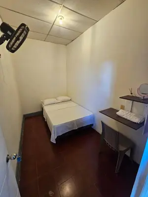 a small room with a bed and a desk at Casa 25 hostal santa ana in Santa Ana
