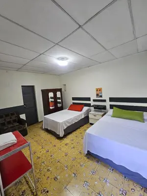 a room with two beds and a table at Casa 25 hostal santa ana in Santa Ana