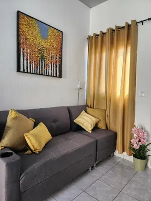a couch in a living room with a painting at Casa América in San Miguel