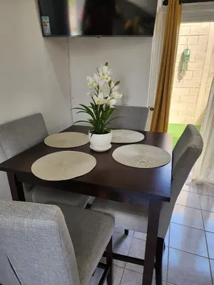 a dining room table with chairs and a vase of flowers at Casa América in San Miguel