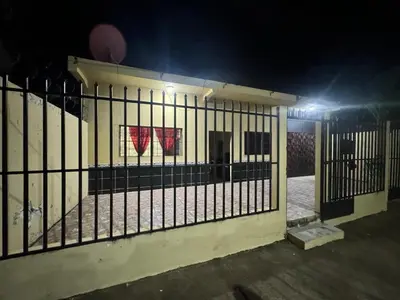 a fence in front of a building at night at Hotel Chalatenango in Nueva Concepción