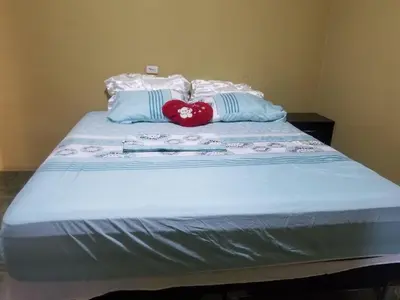 a bed with two pillows with a red heart on it at Hotel Chalatenango in Nueva Concepción