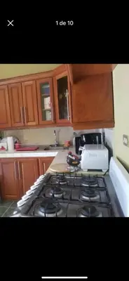 a kitchen with a stove top oven and wooden cabinets at Hotel Chalatenango in Nueva Concepción