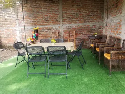 a patio with a table and chairs on green grass at Hotel Chalatenango in Nueva Concepción