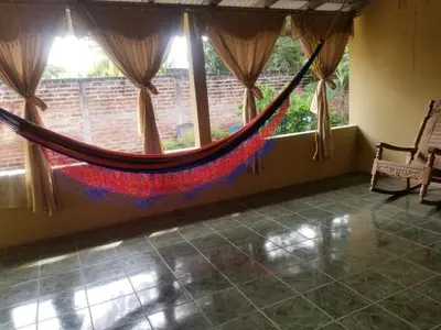 a hammock in a room with a window at Hotel Chalatenango in Nueva Concepción