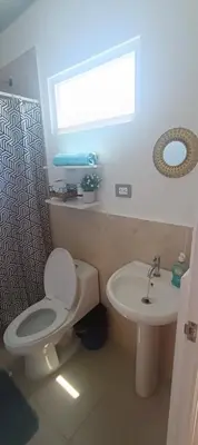 a bathroom with a white toilet and a sink at Casa de Reyes in San Miguel