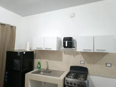 a kitchen with a sink and a black refrigerator at Casa de Reyes in San Miguel