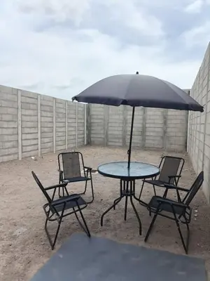 a table and chairs with an umbrella on a patio at Casa de Reyes in San Miguel
