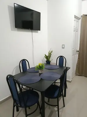 a black table with chairs and a television on a wall at Casa de Reyes in San Miguel