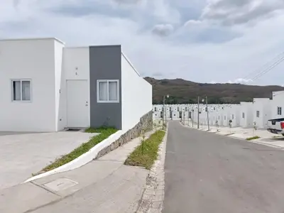 an empty street with white buildings and mountains in the background at Casa de Reyes in San Miguel