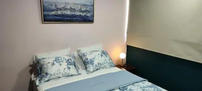 a bed with blue and white pillows and a picture on the wall at La casa de Bába in San Salvador