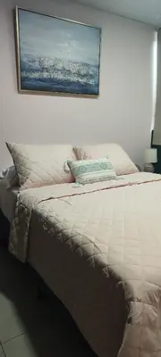 a bed in a bedroom with a picture on the wall at La casa de Bába in San Salvador