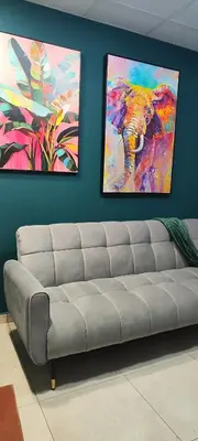 a couch in a room with two paintings on the wall at La casa de Bába in San Salvador