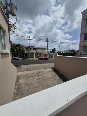 a view of a street with a red car on the road at Livo house in San Salvador in San Salvador