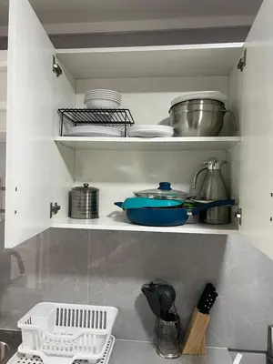 a kitchen with a shelf with dishes and pots and pans at Livo house in San Salvador in San Salvador