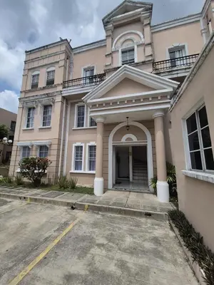 a large pink building with a driveway in front of it at Livo house in San Salvador in San Salvador