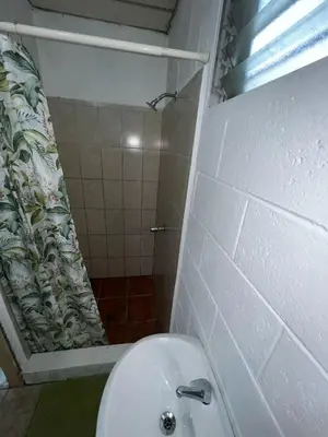 a bathroom with a toilet and a shower at Luxury Hostel Teresita in San Salvador
