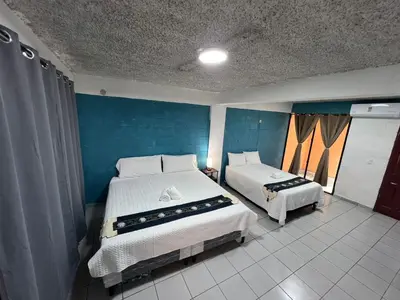 a bedroom with two beds and a blue wall at Luxury Hostel Teresita in San Salvador