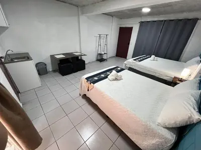 a hotel room with two beds and a table at Luxury Hostel Teresita in San Salvador