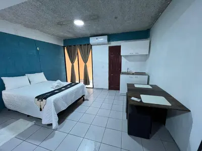 a bedroom with a bed and a table in it at Luxury Hostel Teresita in San Salvador