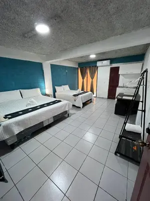 a large room with two beds and a bathroom at Luxury Hostel Teresita in San Salvador