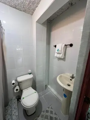 a small bathroom with a toilet and a sink at Luxury Hostel Teresita in San Salvador