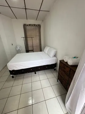 a small bedroom with a bed and a dresser at Luxury Hostel Teresita in San Salvador