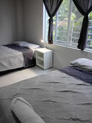 a bedroom with two beds and a nightstand and a window at Apartamento Familiar 2 con 3 habitaciones 4 camas y litera in San Salvador