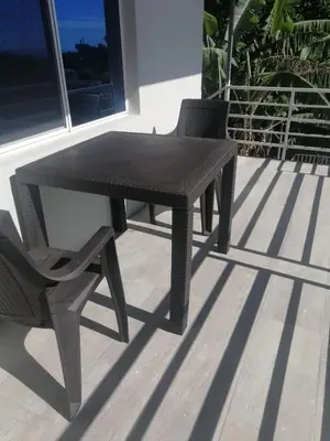 a black table and a chair on a patio at Apartamento Familiar 2 con 3 habitaciones 4 camas y litera in San Salvador