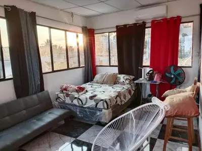 a room with a bed and a couch and windows at Mini penthouse mejor parte SS gran vista! in San Salvador
