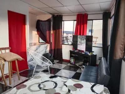 a living room with red curtains and a tv at Mini penthouse mejor parte SS gran vista! in San Salvador