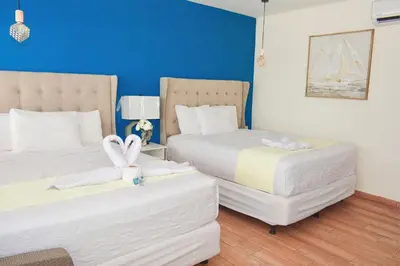 a hotel room with two beds and a blue wall at Hotel y Restaurante Santa Fe in La Libertad