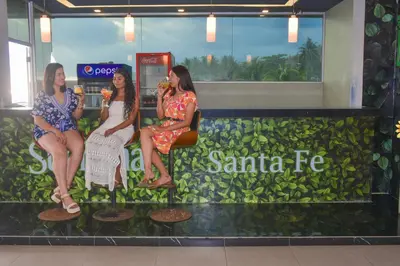 three women sitting on a bench in a santa fe store at Hotel y Restaurante Santa Fe in La Libertad