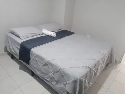a bed in a bedroom with a white pillow on it at Apartamento Familiar 3 con 3 habitaciones 4 camas más litera in San Salvador