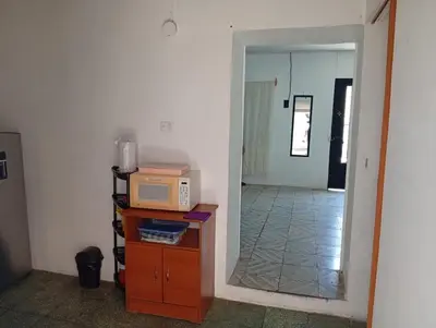 a room with a microwave on a counter and a hallway at La Chola, Guest House in Santa Ana