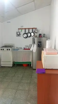 a kitchen with a stove and a table in a room at La Chola, Guest House in Santa Ana