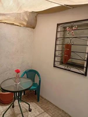 a table and a chair in a room with a mirror at La Chola, Guest House in Santa Ana